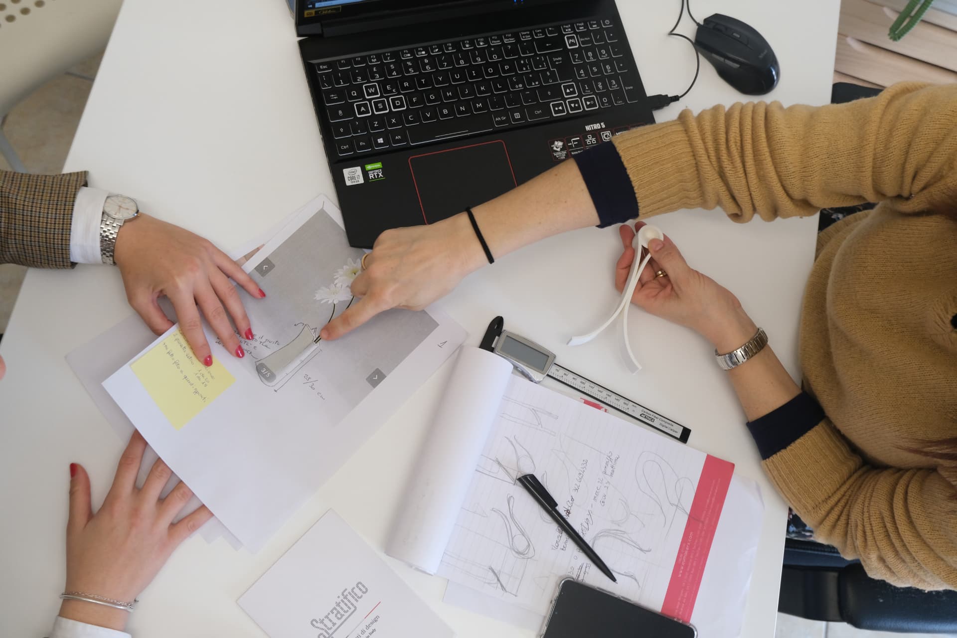 Ritratto in bianco e nero dei due designer di Otto Design al tavolo da lavoro, circondati da modelli geometrici